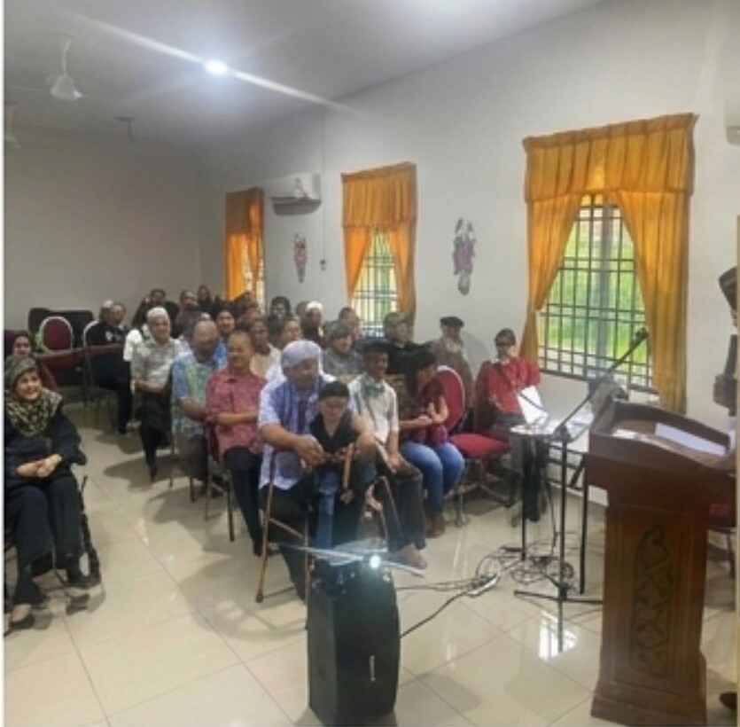 Ahli veteran mendengar taklimat di sebuah dewan di Pasir Gudang